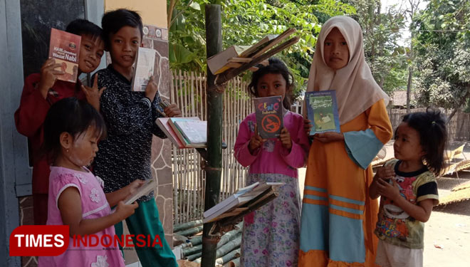 Anak-anak Desa Kalikajar Wetan, Paiton, Probolinggo melihat koleksi buku di Pustaka Pohon Bambu (foto: Saifullah/TIMES Indonesia)