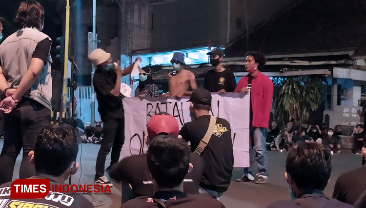Aksi teatrikal yang dilakukan oleh massa yang tergabung dalam Aliansi Lamongan Melawan, saat menggelar aksi solidaritas tindakan represif aparat, Senin (12/10/2020). (FOTO: MFA Rohmatillah/ TIMES Indonesia)