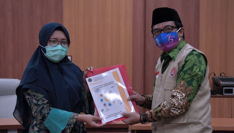 Plt Bupati Jember KH A. Muqit Arief menerima cinderamata dari Dosen UM Jember Maheni Ika Sari, Selasa (13/10/2020). (Foto: Humas Pemkab Jember for TIMES Indonesia)