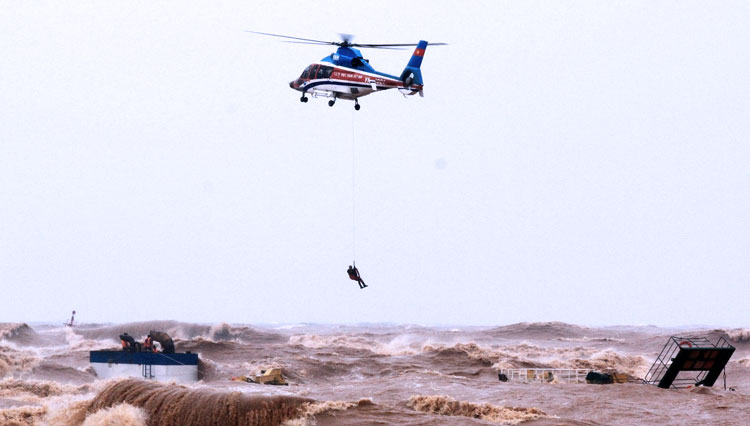 Sebuah helikopter militer tampak sedang menyelamatkan pelaut dari kapal yang tenggelam di Pelabuhan Cua Viet di provinsi Quang Tri, Vietnam.(FOTO: The Canberra Times)