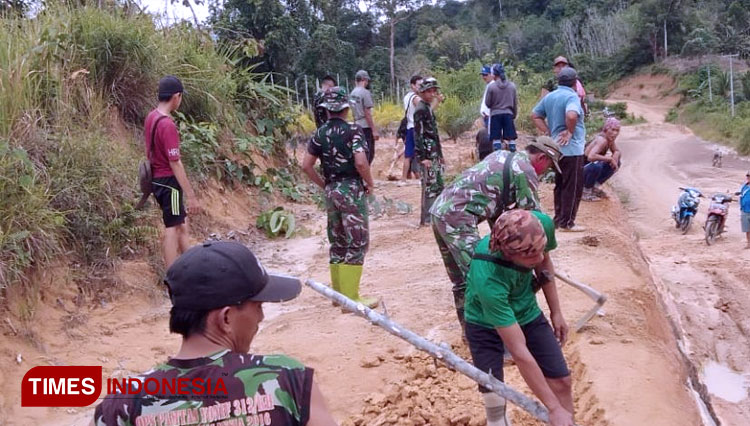 Satgas TMMD Bersama Warga Membersihkan Jalan Poros Desa Tirta Karya Yang Hampir Rampung. (FOTO: AJP/TIMES Indonesia)
