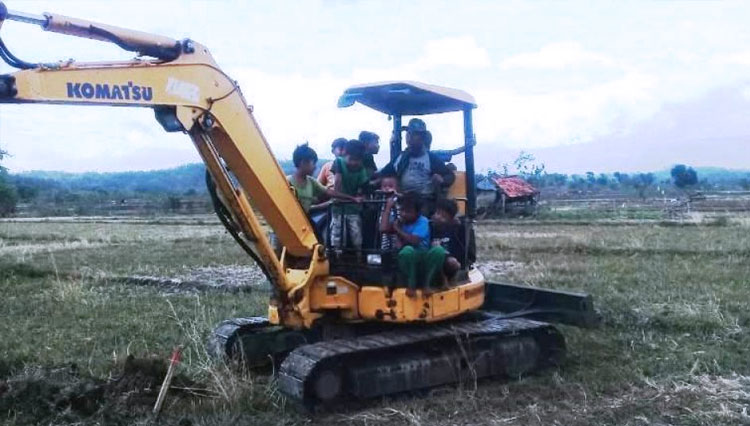 Serma Tarsono, operator excavator Kodim 0713 Brebes, bersama anak-anak Desa Kalinusu, Kecamatan Bumiayu, Kabupaten Brebes, Jawa Tengah.