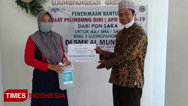 Kepala SMK Al-Muniroh Ujungpangkah Gresik Syamsul Anam saat menerima bantuan APD dari PGN Saka (Foto: Akmal/TIMES Indonesia).