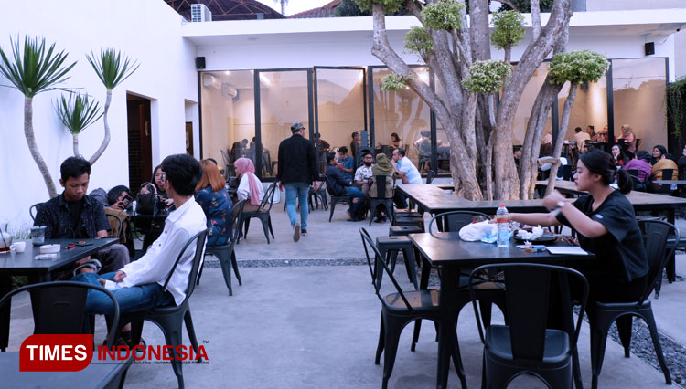 Pengunjung Sebelas Dua Belas Cafe menikmati suasana senja di cafe. (Foto: Naufal Ardiansyah/TIMES Indonesia)