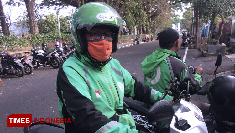 Driver Gojek, Edy Sugianto melengkapi tubuhnya dengan beberapa APD untuk patuh protokol kesehatan. (Foto: Irfan Anshori/TIMES Indonesia)