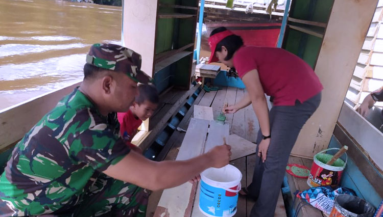 Satgas TMMD 109/ Sintang dibantu beberapa Pengajar Wanita tengah menghias perahu/ kapal yang akan digunakan sebagai tempat Perpustakaan Apung (Foto: ajp.TIMES Indonesia)
