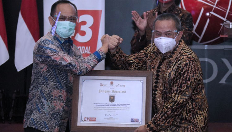 Dirjen Dukcapil Kemendagri Zudan Arif Fakrulloh saat menerima penghargaan dari OJK. (FOTO: Kemendagri)