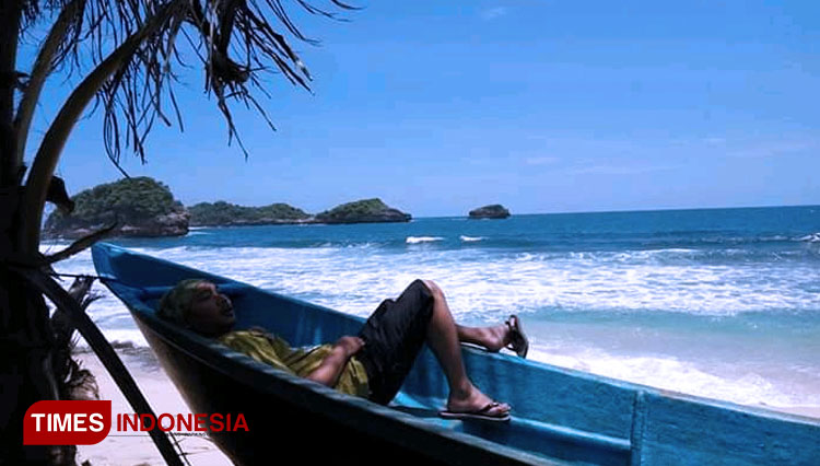 Seorang pengunjung sedang menikmati desiran angin pantai Peh Pulo, Senin (19/10/2020). (Foto: Sholeh TIMES Indonesia)