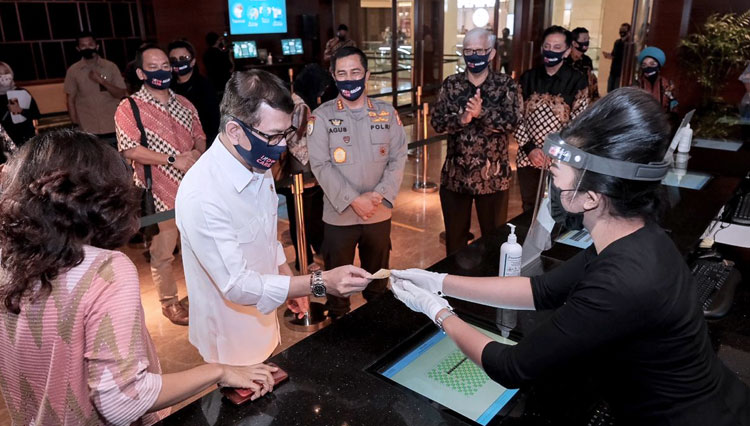 Menteri Pariwisata Wishnutama dengan APD menerima karcis bioskop dari petugas dalam simulasi pembukaan bioskop di Jakarta beberapa waktu lalu. (foto: Kemenparekraf RI)