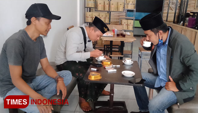 Pengunjung berpakaian ala santri tampak menikmati kopi di kedai 'Tukang Goreng Kopi'. Di HSN ini, khusus warga berkostum Santri bisa menikmati kopi secara gratis (FOTO: Moh Bahri/TIMES Indonesia).