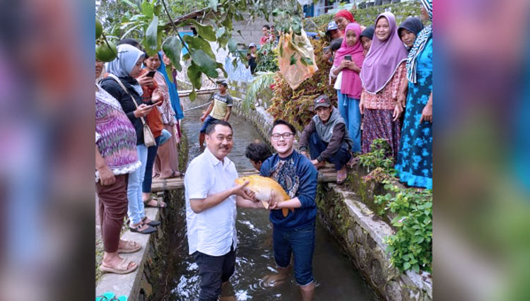 Cabup Banyuwangi, Nomor Urut 1, Yusuf Widyatmoko (kiri) bersama artis Danang Pradana Dieva (kanan), saat menangkap ikak koi di Kampung Koi, Desa Kluncing, Kecamatan Licin. (Foto : Rizki Alfian/TIMES Indonesia)