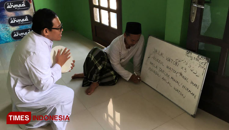 Ketua Komisi Hubungan Antar Keyakinan Keuskupan Agung Semarang, Romo Didik Cahyono SJ sedang membaca lirik Ya Lal Wathan dipandu oleh seorang santri. (Foto: Mushonifin/TIMES Indonesia)