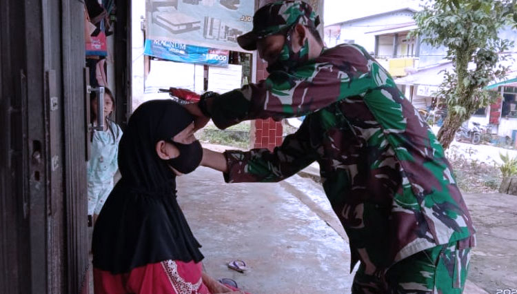 Peduli Kesehatan, Prada Agus Memasangkan Masker Pada Bu Eni