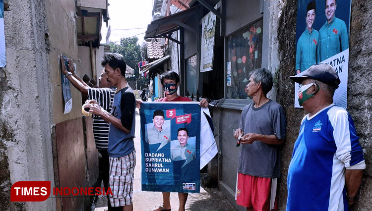 Warga pendukung paslon nomor urut 3 Dadang Supriatna-Sahrul Gunawan sedang memasangkan APK Paslon Bedas di lingkungannya. (FOTO : Tim Bedas for TIMES Indonesia)