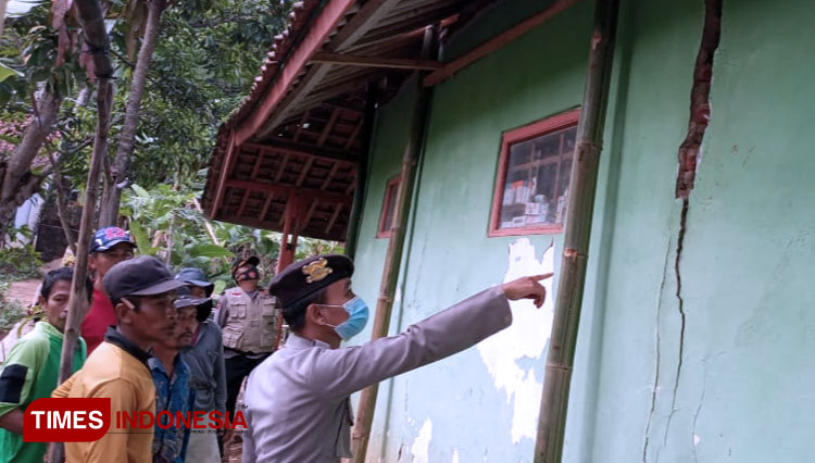 Anggota Kepolisian Polsek Lemahsugih, Polres Majalengka mengecek kondisi rumah warga yang terkena pergerakan tanah. (FOTO: Humas Polres Majalengka for TIMES Indonesia)