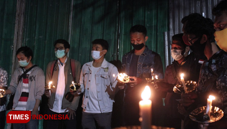 Komunitas anak muda 'Wong Suroboyo' saat melakukan refleksi sejarah dengan menyalakan lilin di depan Rumah Radio Pemberontakan Bung Tomo. (Foto: Khusnul Hasana/TIMES Indonesia)