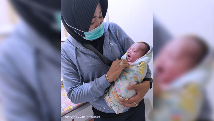 Bidan Siti Siti Indriyani bersama bayi mungil bernama Wira Ananta Rudira. Siti membantu kelahiran bayi tersebut dalam kondisi darurat saat berada di Pasar Pabean, Surabaya pada Senin (9/11/2020) lalu. (FOTO: Dok.Koarmada II) 