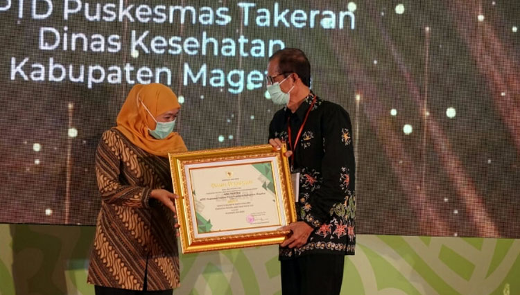 Bupati Magetan Suprawoto saat menerima penghargaan dari Gubernur Jatim Khofifah Indar Parawansa. (Foto: Dok. Pemkab Magetan) 