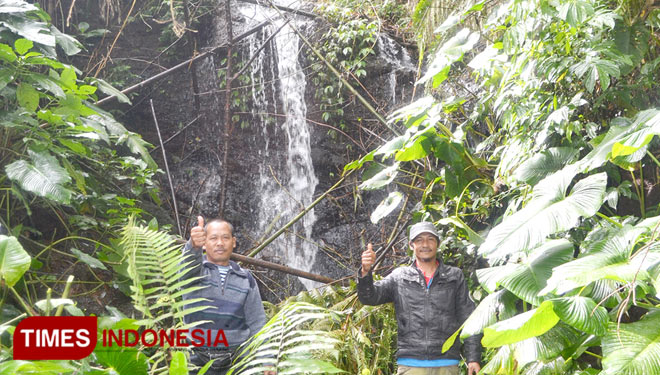 The visitors pose in front of Cinta Kasih waterfall while admiring the beauty of natural scenery. (Photo: Asnadi/ TIMES Indonesia)