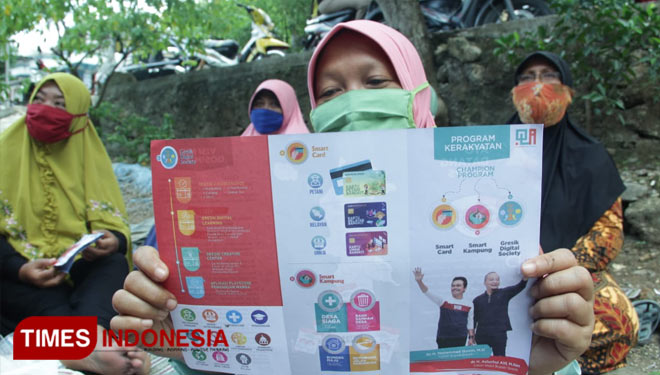 Warga saat membaca brosur rencana pengkoneksian wisata Surowiti dan ziarah wali (Foto: Akmal/TIMES Indonesia).