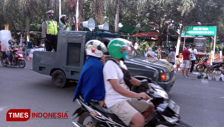 Tampak petugas dari Polres Bondowoso menggunakan mobil patroli berkeliling mengingatkan protokol Kesehatan di tempat-tempat keramaian (FOTO: Moh Bahri/TIMES Indonesia).