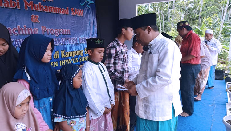Ketua BAZNAS Jember KH M. Misbahus Salam memberikan santunan kepada anak yatim Pondok Pesantren Ihyaus Sunnah di Kampung SDGs Desa Tugusari, Jember, Sabtu (14/11/2020). (Foto: BAZNAS Jember for TIMES Indonesia)