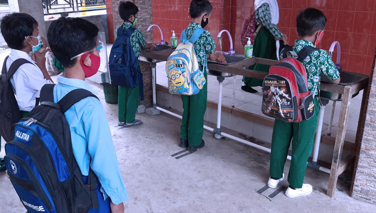 Pelajar MI Miftahul Ulum, Wonomerto, Kabupaten Probolinggo mencuci tangan pakai sabun sebelum masuk ruang kelas (foto: Muiz for TIMES Indonesia)