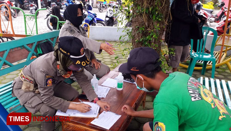 Petugas satpol PP Kabupaten Blitar sedang memberikan surat teguran kepada pelanggar Protokol Kesehatan dalam operasi yustisi di kecamatan Gandusari, Selasa (17/11/2020). (Foto: Kominfo Kab Blitar)