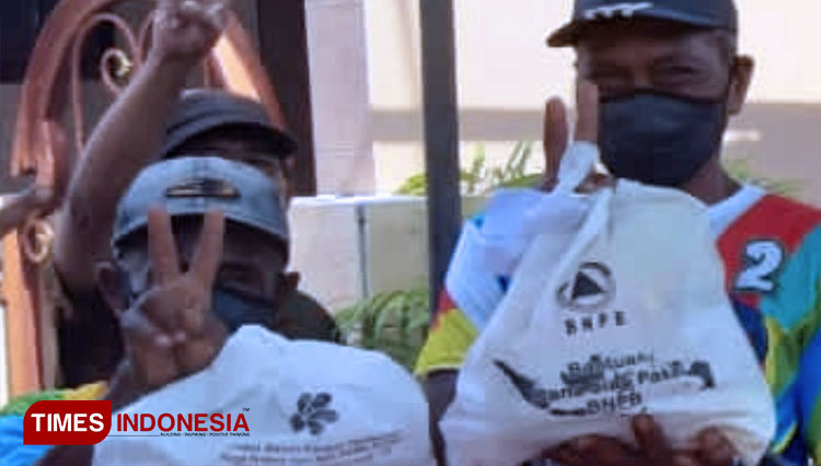 Warga dengan kostum kampanye Machfud-Mujiaman menerima bantuan BNPB. (FOTO: Tangkapan layar/TIMES Indonesia)