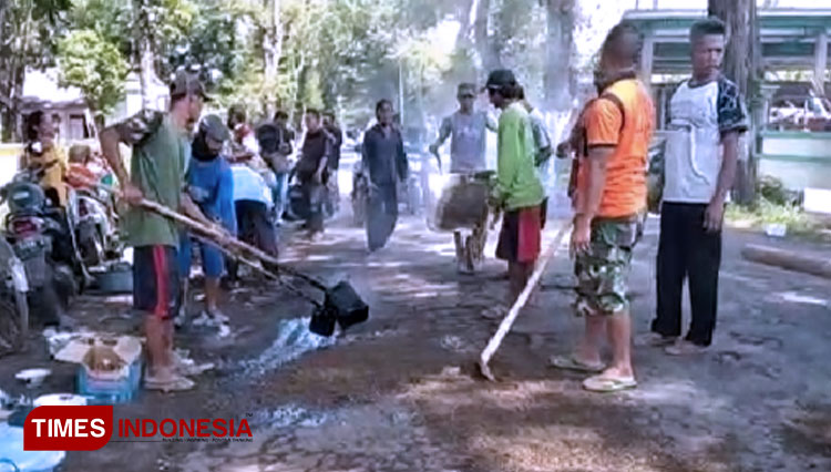 Tampak warga mulai menbal lubang dan aspal yang mengelupas di sepanjang Jalan Raya Tamanan-Bondowoso Kabupaten Bondowoso Jawa Timur (FOTO: Moh Bahri/TIMES Indonesia).