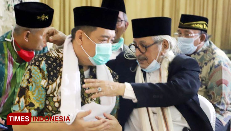 Habib Muhammad bin Smith mengalungkan serban putih miliknya kepada Cabup Sidoarjo Kelana Aprilianto, Sabtu (21/11/2020). (Foto: Lely Yuana/TIMES Indonesia) 