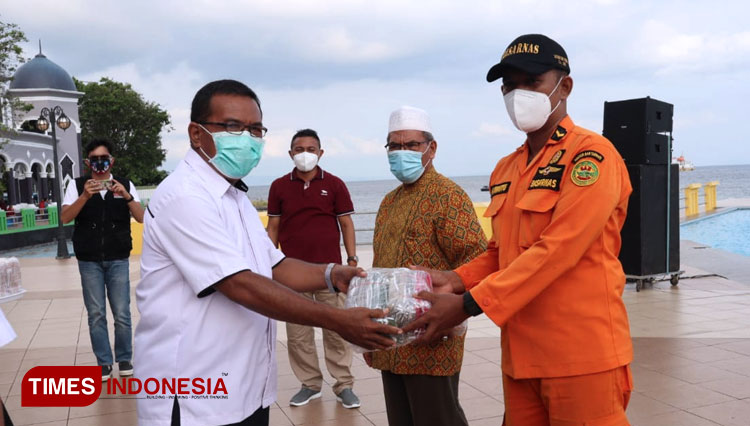 Penyerahan masker secara simbolis oleh Asisten II Gubernur kepada Kepala Kantor Basarnas Ternate. (Foto: Wahyudi Yahya/TIMES Indonesia)