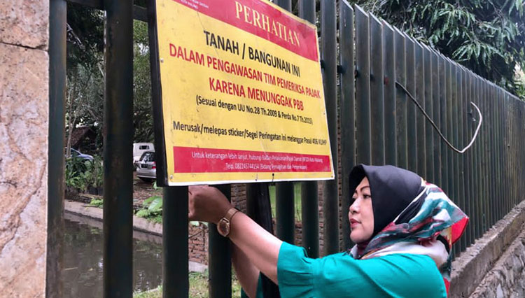 Petugas Bapenda Kota Malang menindak WP menunggak. (Foto: Humas Bapenda Kota Malang)  
