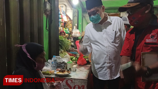 Cabup Sidoarjo Kelana Aprilianto saat berbincang dengan Siti Mariyam, pedagang lontong di Pasar Baru Wadung Asri, Selasa (24/11/2020). (Foto : Lely Yuana/TIMES Indonesia) 