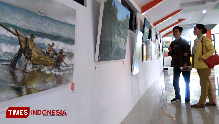 Pengunjung sedang menikmati pameran lukisan karya anak-anak muda Indramayu.(Foto:Muhamad Jupri/TIMES Indonesia)