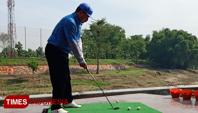 Wali Kota Madiun H. Maidi bermain golf di driving range di Taman Lalu Lintas Bantaran Kali Madiun. (Foto: Aditya Candra/TIMES Indonesia)