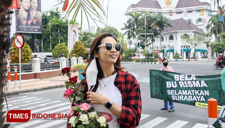 Salah satu anggota Anak Muda Milenial Surabaya menggelar aksi berbagi bunga mawar sebagai bentuk bela Wali Kota Risma. (Foto: Amelia for Times Indonesia)