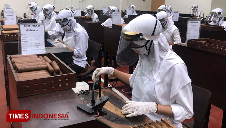 Karyawan BIN Cigar menggunakan APD lengkap saat membuat cerutu dalam acara pelepasan ekspor secara nasional, Kamis (3/12/2020). (Foto: Achmad Fauzi/TIMES Indonesia)