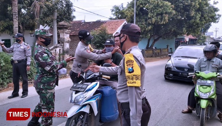 Personil Polsek Proppo bersama Koramil Proppo saat menggelar Operasi Yustisi Protokol COVID-19 di Jalan raya depan Mapolsek Proppo Polres Pamekasan. (FOTO: Akhmad Syafi'i/TIMES Indonesia)