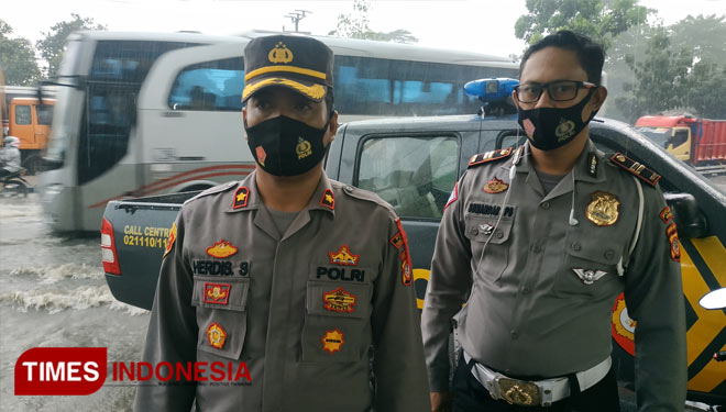 Kapolsek Cimanggung Kompol Herdis Suhardiman didampingi Panit Lantas IPTU Sunandar saat dilokasi genangan air di Jalan raya Bandung-Garut KM 23 (FOTO: Alan Dahlan/TIMES Indonesia)