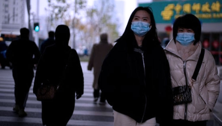 Sudah satu tahun sejak ada gelombang infeksi Covid-19, warga Wuhan tetap disiplin mengenakan masker kemana-mana meski kotanya sudah kembali membaik. (FOTO: Reuters)