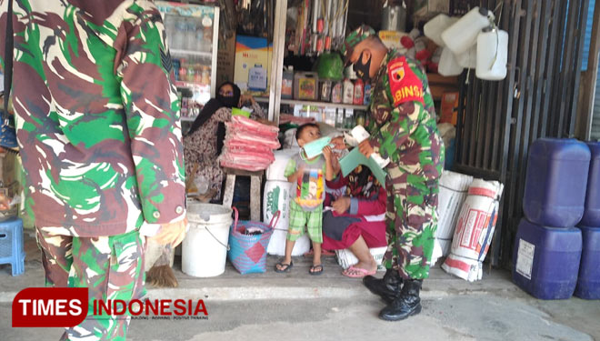 Prajurit Koramil Singgahan Kodim Tuban saat operasi kemanusiaan dan berbagi masker kepada warga setempat, Minggu (20/12/2020). (Foto: Ahmad Istihar/TIMES Indonesia)