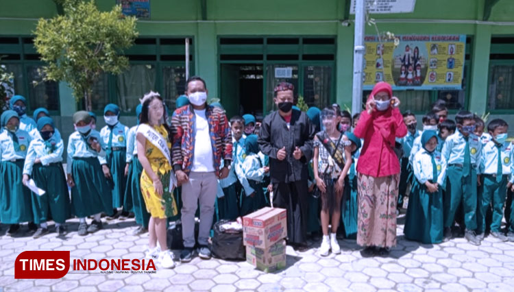 Puteri Cilik Indonesia 2020, Angelique Janavieve saat bersama Owner Batik Ka_De Pamekasan, Abdus Somad ketika memberikan bantuan alat tulis ke SDN Panggung 1, Kabupaten Sampang, Madura.(Foto: Akhmad Syafi'i/TIMES Indonesia)