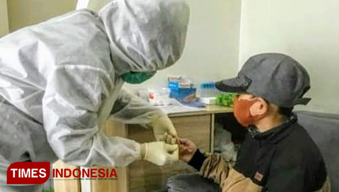 Tenaga medis Medifast Laboratorium Sidoarjo melakukan layanan rapid test kepada pasien, Minggu (3/1/2021). (Foto : Lely Yuana/TIMES Indonesia)