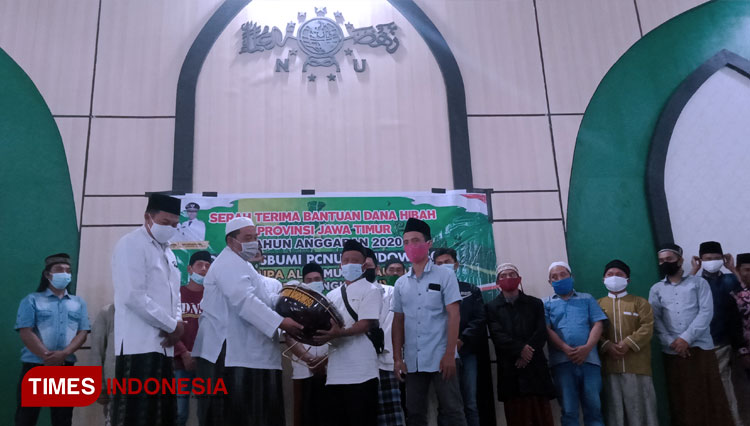 Ketua Tanfidziah PCNU Bondowoso KH Abd Qodir Syam bersama Ketua Lesbumi dan Ketua Fraksi PKB DPRD Bondowoso menyerahkan langsung bantuan alat musik hadrah kepada sejumlah kelompok. (FOTO: Moh Bahri/TIMES Indonesia)