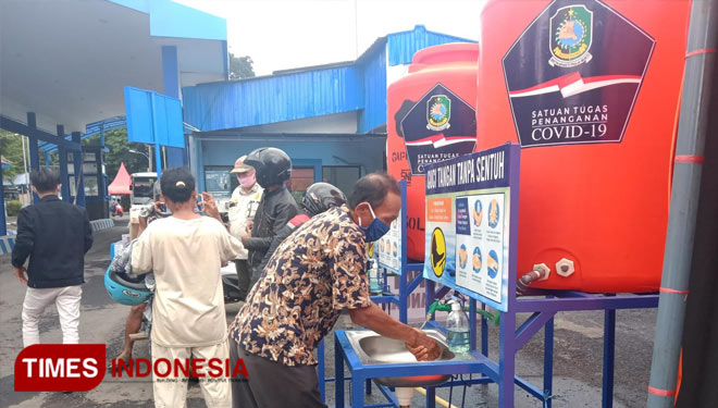 Para pengendara yang melintas diberlakukan wajib mencuci tangan oleh satgas Covid-19 Kabupaten Banyuwangi dalam operasi check point. (Foto : Riswan Efendi/TIMES Indonesia)