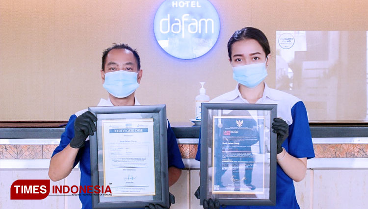 Food beverage manager dan front desk agent hotel Dafam Cilacap, menunjukan sertifikat yang diraih hotel tersebut. (FOTO: Adhelya Fhifhahamni for TIMES Indonesia)