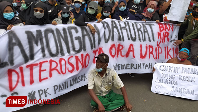 Pendemo membentangkan sepanduk berisi keluhan, lantaran setiap tahun kawasan Bengawan Njero terdampak banjir, saat menggelar aksi di depan Kantor DPRD Lamongan, Rabu (13/1/2021). (FOTO: MFA Rohmatillah/TIMES Indonesia)