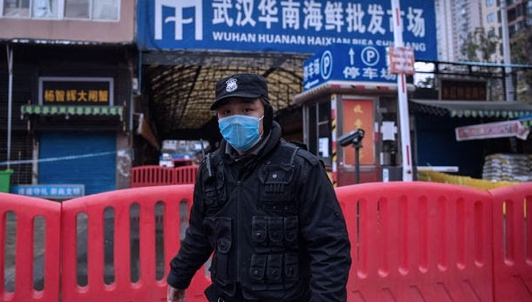 Seorang petugas polisi menjaga Pasar Grosir Makanan Laut Huanan yang ditutup, dan suasana di luar sebuah mal di Wuhan.(FOTO:The Wall Street Journal/Getty Image)