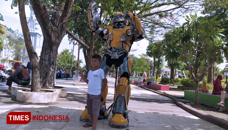 Pengunjung mengabadikan momen bersama robot di Alun-alun Lamongan. (FOTO: MFA Rohmatillah/TIMES Indonesia)